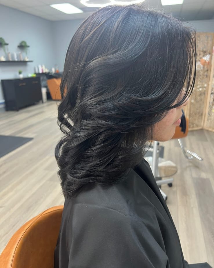 Peinado con volumen y ondas amplias en cabello oscuro